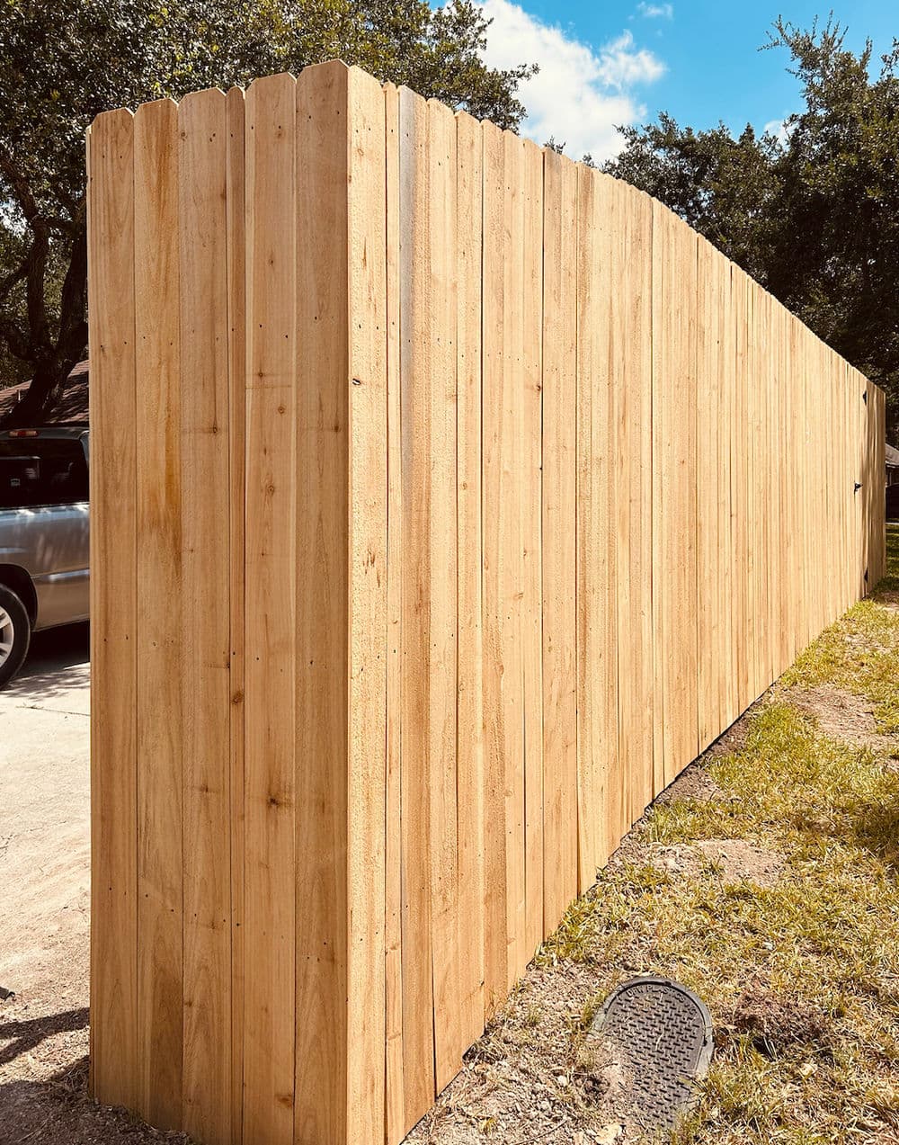 New wooden privacy fence installed along grassy area, enhancing outdoor space and security.